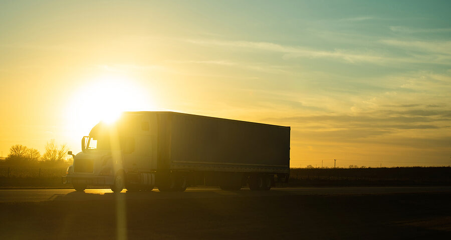 truck owner operator driving off through the sunset.